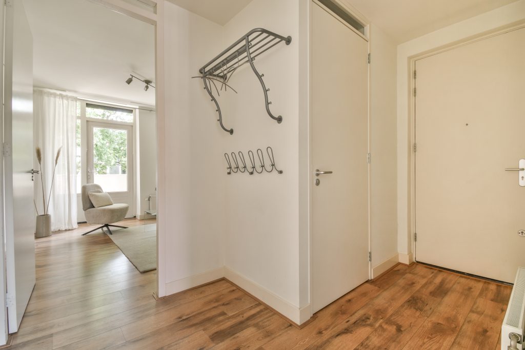 Doorway of modern apartment with white walls and parquet floor